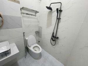 a white bathroom with a toilet and a shower at Lami House in Danang