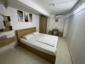 a bedroom with a bed with white sheets and pillows at Lami House in Danang