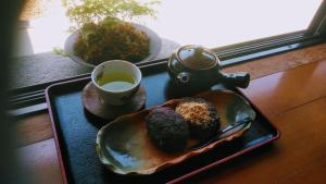 a tray with a plate of muffins and a cup of tea at Minpaku Nambu in Koka