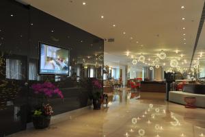 a lobby with a tv on the wall and a room with at Kaohsiung International Plaza in Kaohsiung