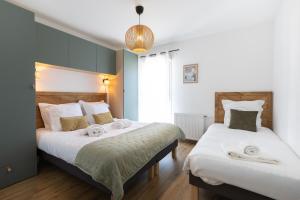 a bedroom with two beds with white sheets at "Lac'Almie" - Appartement 2 chambres avec Terrasse et Parking in Doussard
