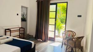 a bedroom with a bed and a sliding glass door at Mashi's Villa in Sigiriya