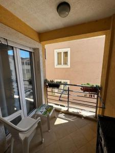 a room with a balcony with a chair and a window at Apartman Tafra1 in Igalo