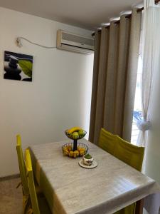 a table with a bowl of fruit and a plate of food at Apartman Tafra1 in Igalo