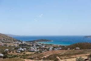 a view of a town on a hill next to the ocean at Stunning View Sarakiniko Villa in Agios Petros
