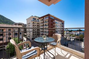 a balcony with a table and chairs and buildings at Villa Ines in Budva