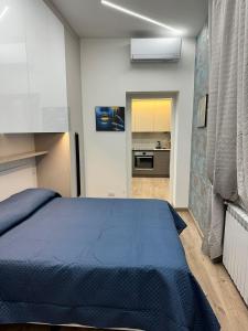 a bedroom with a blue bed and a kitchen at Appartamento Svetlana Segrate in Segrate