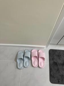 three pairs of pink and white slippers on a floor at 529 Cozy rooms in Ban Si Than