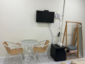 a table and two chairs and a tv on a wall at 529 Cozy rooms in Ban Si Than +16 photos