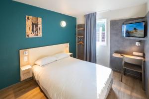 a bedroom with a white bed and a blue wall at ibis budget Orange Centre in Orange +34 photos