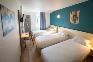 a hotel room with two beds and a desk at ibis budget Orange Centre in Orange