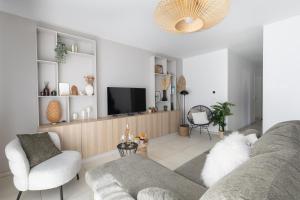 a living room with a couch and a tv at "Lac'Almie" - Appartement 2 chambres avec Terrasse et Parking in Doussard +19 photos