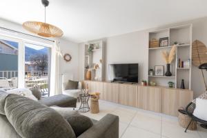 a living room with a couch and a tv at "Lac'Almie" - Appartement 2 chambres avec Terrasse et Parking in Doussard