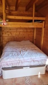a bed in a room with wooden walls at STUDIO indépendant dans un chalet traditionnel in Ban-sur-Meurthe-Clefcy