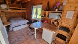 a room with a table and a bed in a cabin at STUDIO indépendant dans un chalet traditionnel in Ban-sur-Meurthe-Clefcy