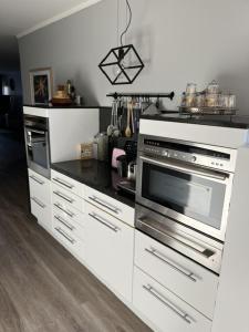a kitchen with stainless steel appliances and white cabinets at Room 1 km from tomorrowland in Boom