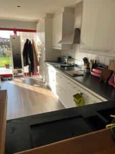 a kitchen with white cabinets and a black counter top at Room 1 km from tomorrowland in Boom +1 photo