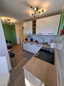 a kitchen with white cabinets and a counter top at Apartman Roko in Gospić