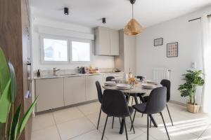 a kitchen and dining room with a table and chairs at "Lac'Almie" - Appartement 2 chambres avec Terrasse et Parking in Doussard