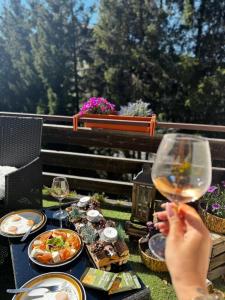 a person holding a glass of wine on a table with food at Wuthering Heights in Angolo Terme