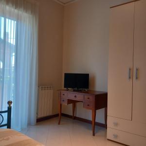 a bedroom with a desk with a television on it at New Magnolia House in Belpasso