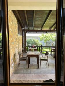 a patio with a table and chairs and a brick wall at Bujtina Valgent in Berat