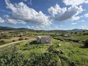 a building in the middle of a field with a road at Maison d'hôte Yeswal in Guezira