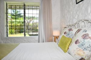 a bedroom with a white bed and a window at Beach Escape in Trou d'Eau Douce +40 photos