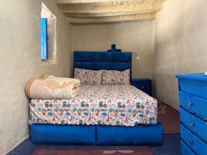 a bedroom with a blue bed and a blue dresser at Maison d'hôte Yeswal in Guezira