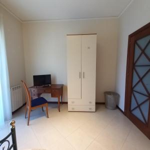 a room with a desk and a cabinet and a computer at New Magnolia House in Belpasso