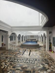 a large building with a swimming pool in a lobby at Blessing Hotel Pandan in Halangan +3 photos