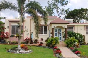 a house with a palm tree in the front yard at Eden's Garden in Isabela