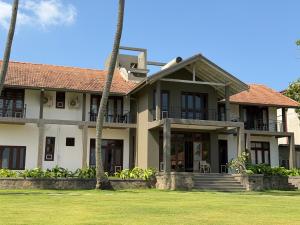 a house with palm trees in front of it at Aayu Lagoon in Negombo