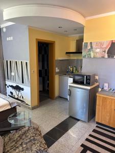 a living room with a microwave and a kitchen at Pension Wolkenrasen in Sonneberg