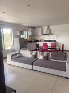 a living room with a couch and a kitchen at Central Apartment in Nadi