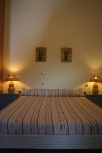 a bedroom with a bed with two lamps on it at Chrisoula Studios in Kámbos