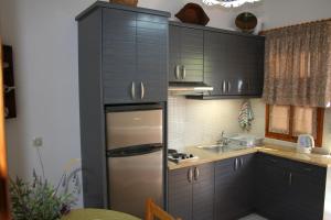 a kitchen with black cabinets and a stainless steel refrigerator at Chrisoula Studios in Kámbos