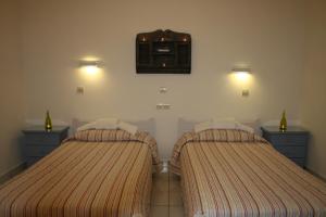 a bedroom with two beds and a mirror on the wall at Chrisoula Studios in Kámbos