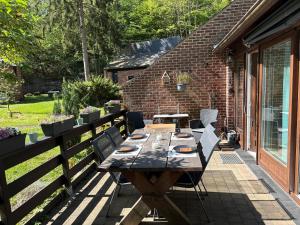a wooden table and chairs on a patio at Domaine du Bonsoy--Azur in Blaimont