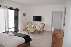 a bedroom with a bed and a table and chairs at VillaRama in Saint-Louis