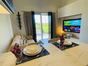 a living room with a table with plates and a tv at 2 Modern guesthouses near The Beach in Falkenberg