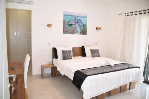 a bedroom with a large bed with white sheets at VillaRama in Saint-Louis +27 photos