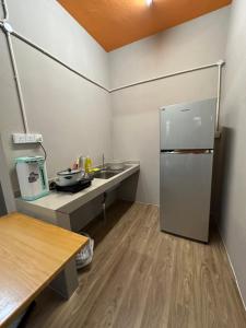 a small kitchen with a refrigerator and a counter at Baby Devil Studio 8 pax Homestay in Sibu