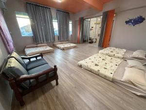 a bedroom with two beds and a chair in it at Baby Devil Studio 8 pax Homestay in Sibu