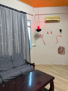a living room with a couch and a table at Baby Devil Studio 8 pax Homestay in Sibu