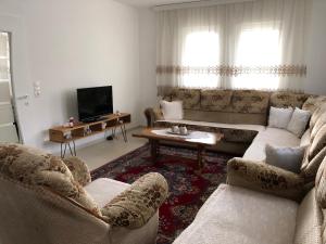 a living room with two couches and a tv at Rugova Vila in Peje