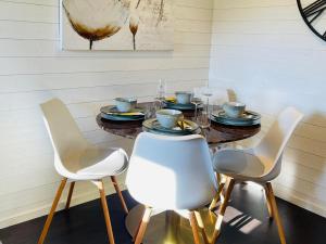 a dining room table with white chairs and a wooden table at 2 Modern guesthouses near The Beach in Falkenberg