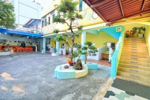 a building with a tree in the middle of a courtyard at Fumigate Hotel in Hengchun South Gate
