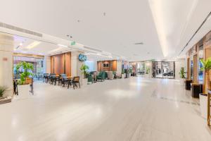 an empty lobby of a building with tables and chairs at Grand Plaza Al Madina in Medina