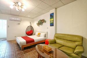 a hotel room with a bed and a couch at Fumigate Hotel in Hengchun South Gate +8 photos